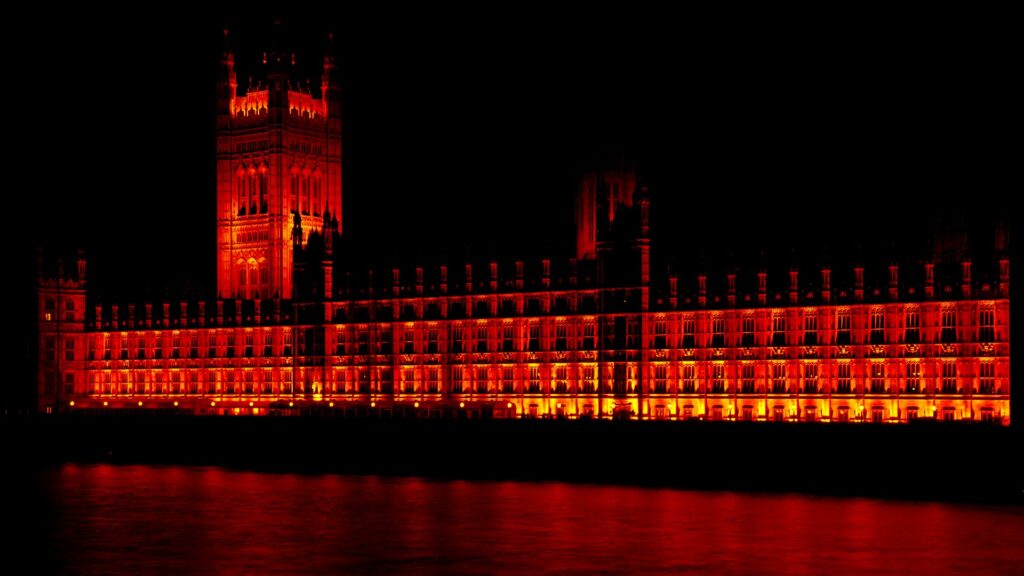 Houses of parliament at night. A red filter gives a more demonic look to contrast the myth that the government works for you